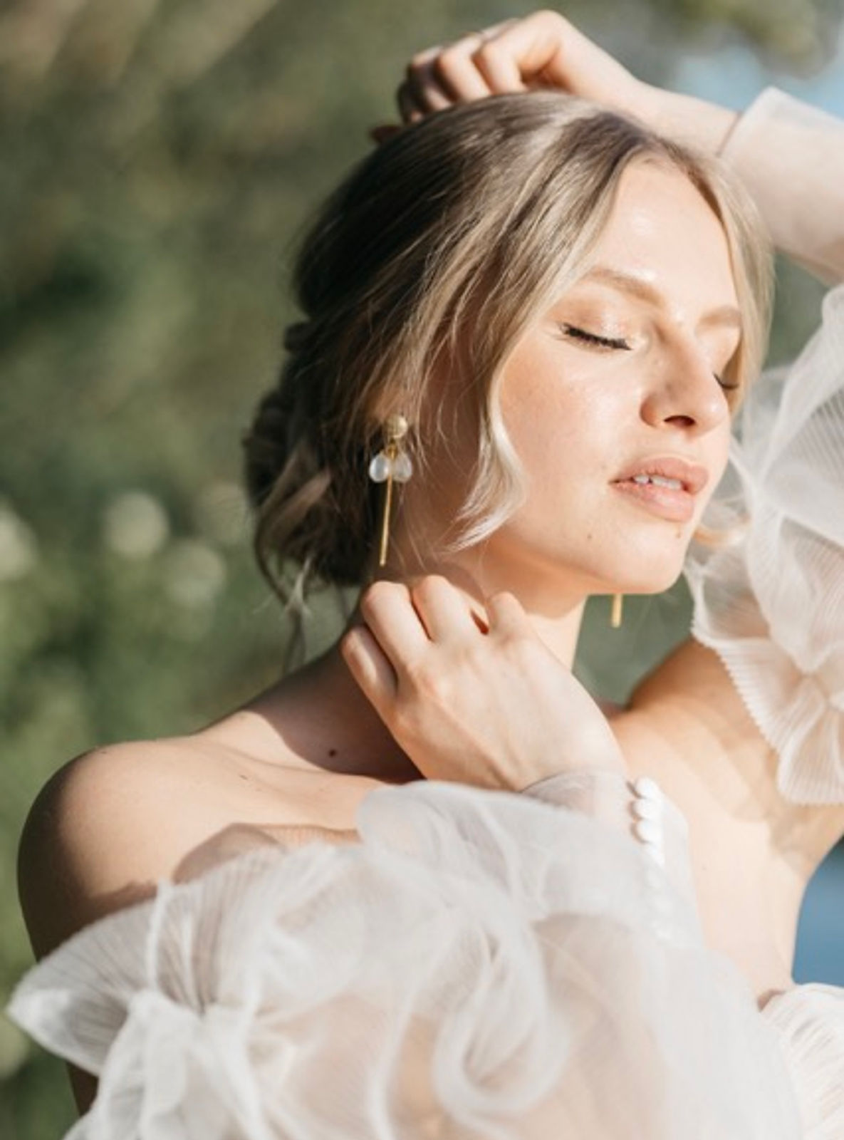 Braut mit natürlichem Brautstyling und lockigem Dutt 